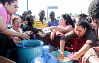 Nazarenos dan alimentos a migrantes africanos